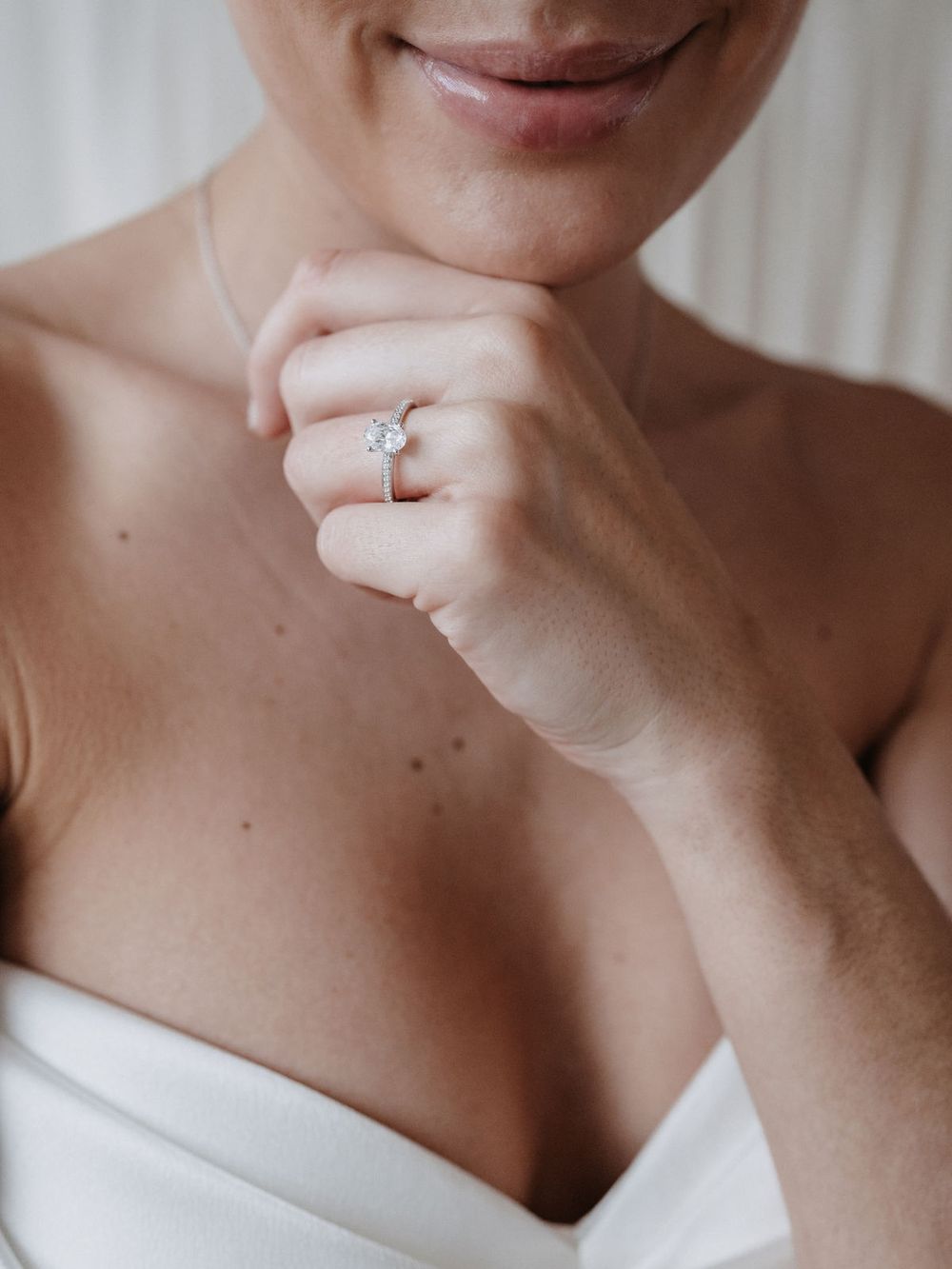 Braut mit Verlobungsring, Hand am Kinn