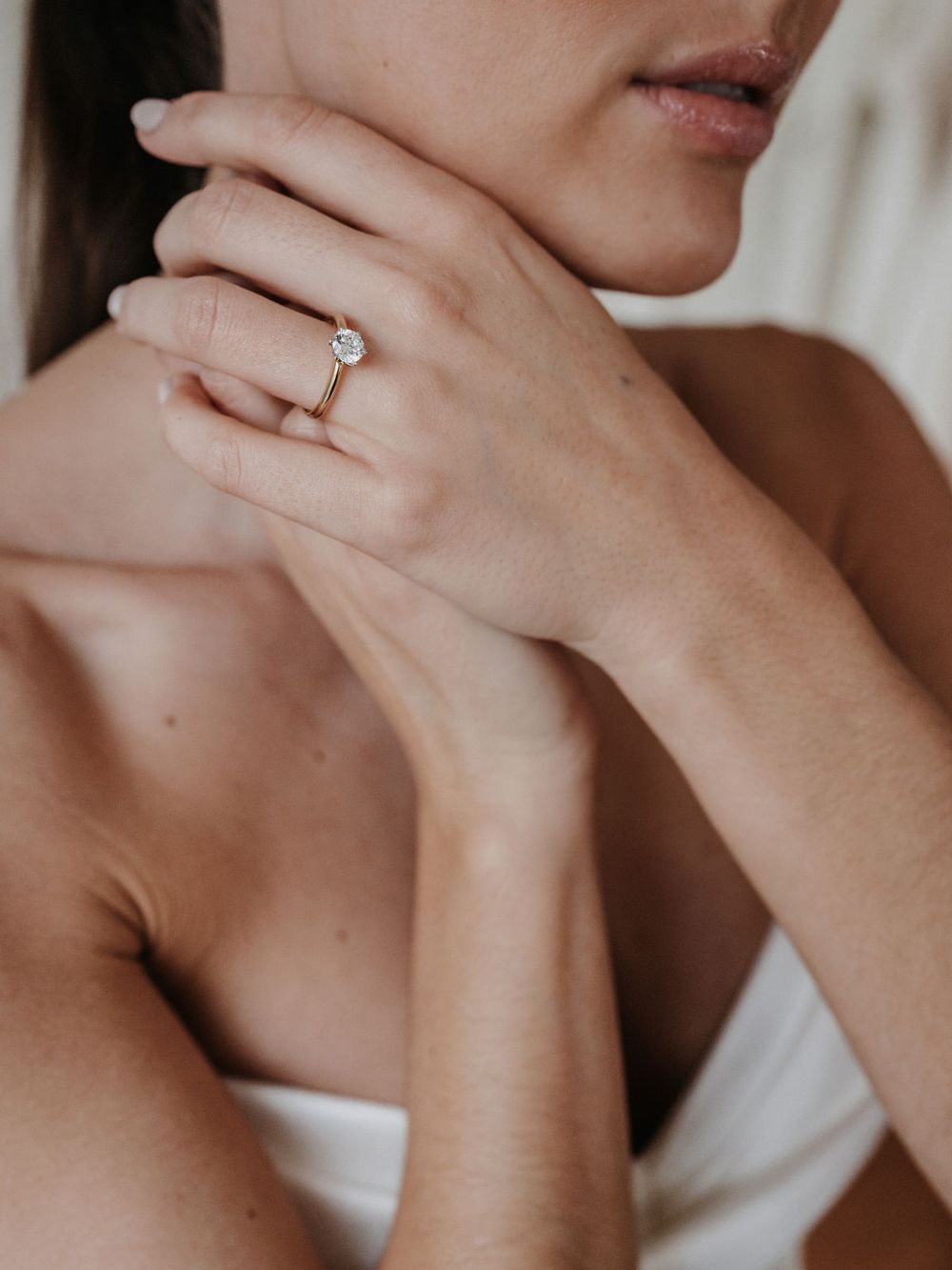 Braut mit Verlobungsring, Hand am Kinn