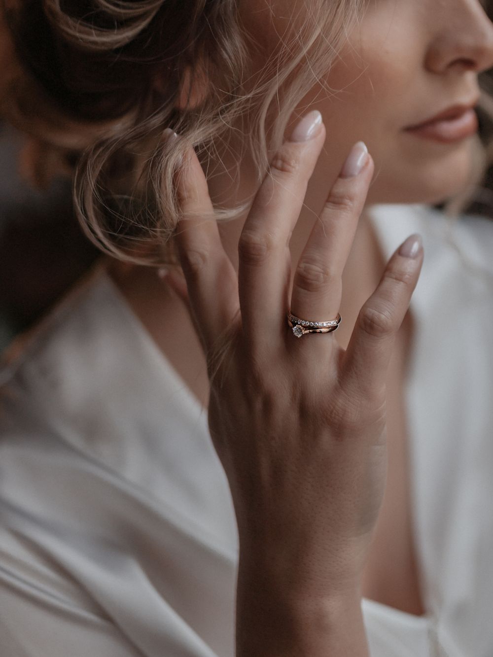 Frau mit mehreren Ringen, Hand am Gesicht
