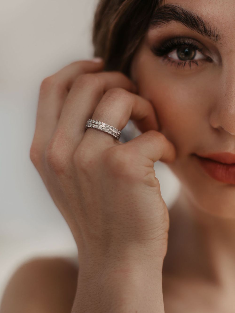 Trauring mit Brillantreihe am Finger, Hand an der Wange