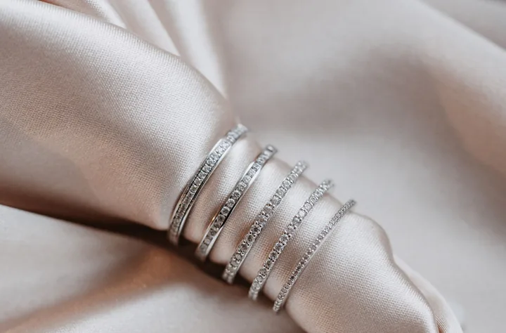 Mehrere schmale Memoire-Trauringe mit Brillanten auf hellem Satin, Juwelier Otto Parr in Gießen