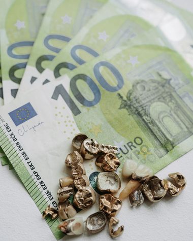 Mehrere 100-Euro-Scheine neben Zahngold, Auszahlung beim Goldankauf im Geschäft