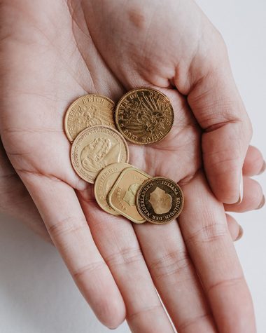 Geöffnete Handfläche mit mehreren Goldmünzen