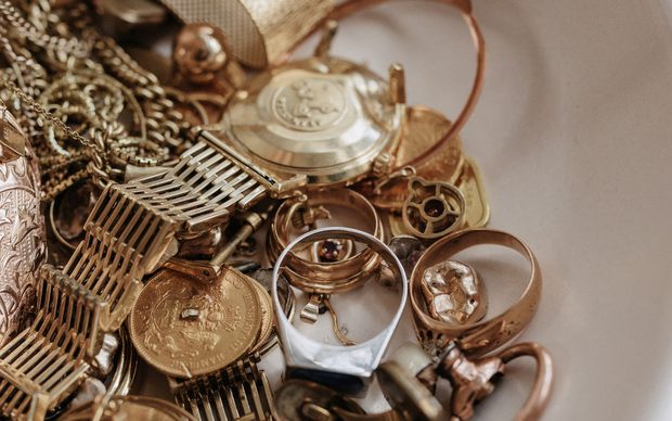 Weiße Schale gefüllt mit altem Goldschmuck und Ketten